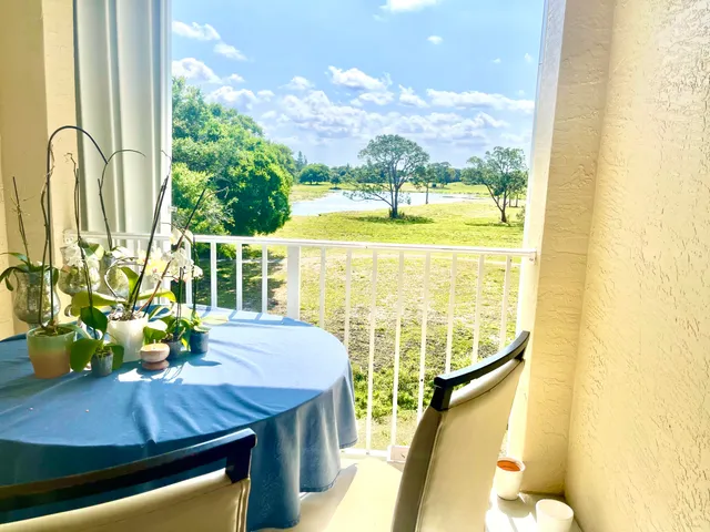 a view of a dining room with furniture a chandelier window and outside view