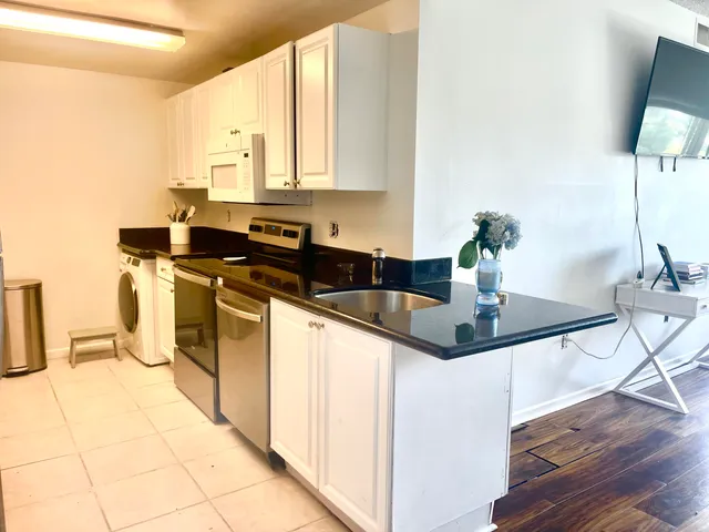 a kitchen with stainless steel appliances a sink a counter top space and cabinets