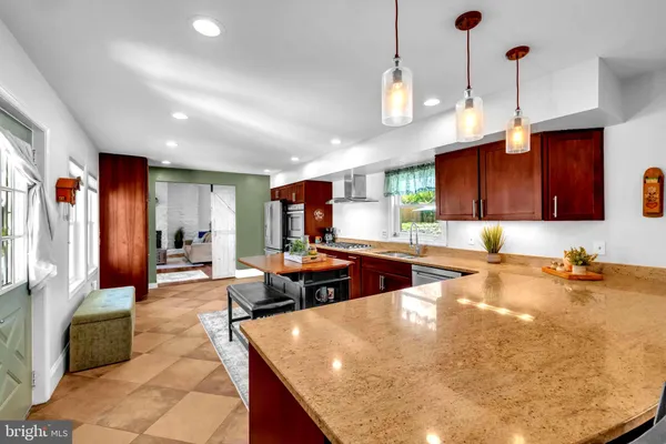 a kitchen with stainless steel appliances granite countertop a sink counter space and living room view