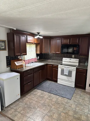 a kitchen with a stove sink and cabinets