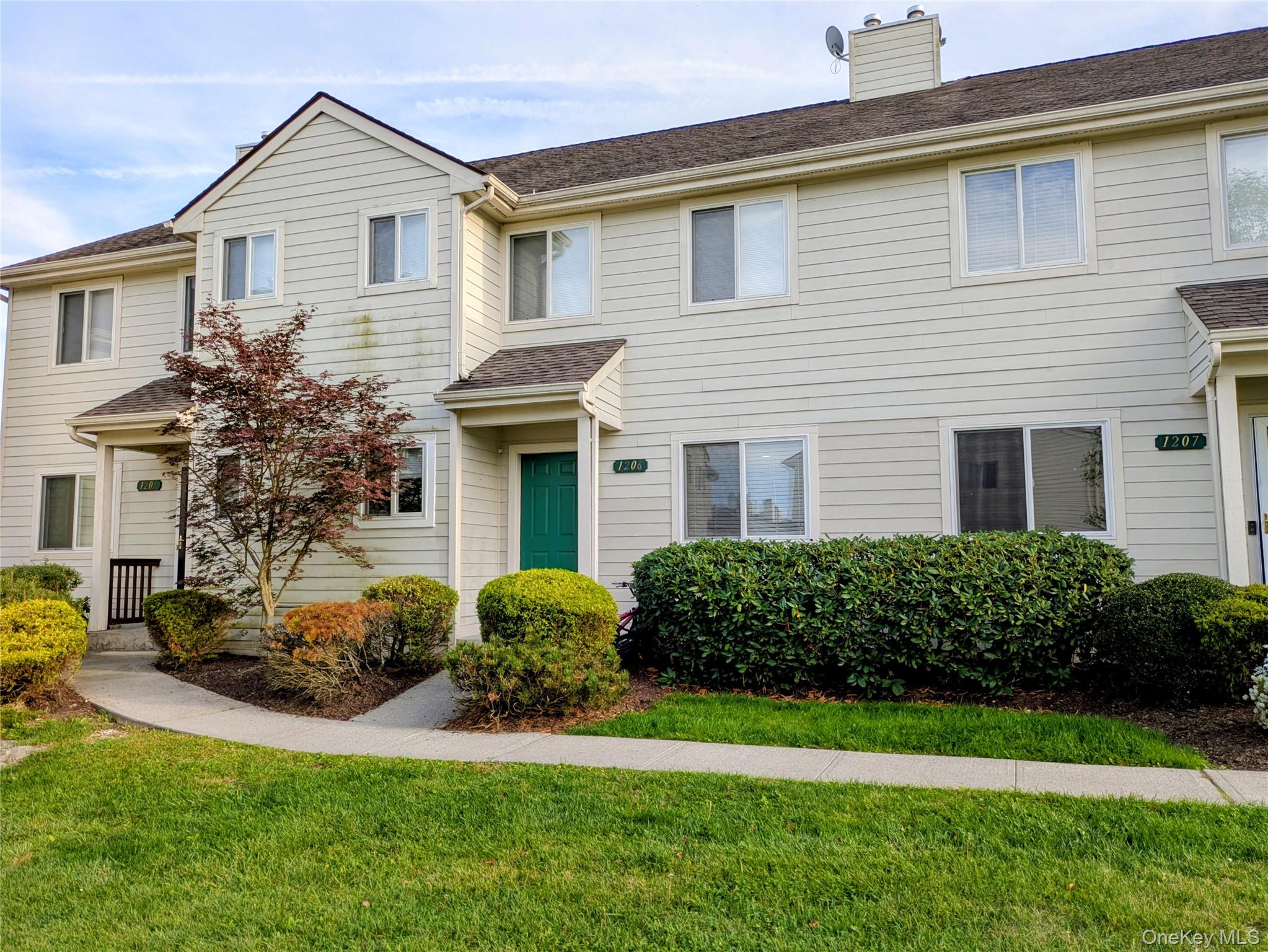 Traditional home with a front lawn, a chimney, and a shingled roof