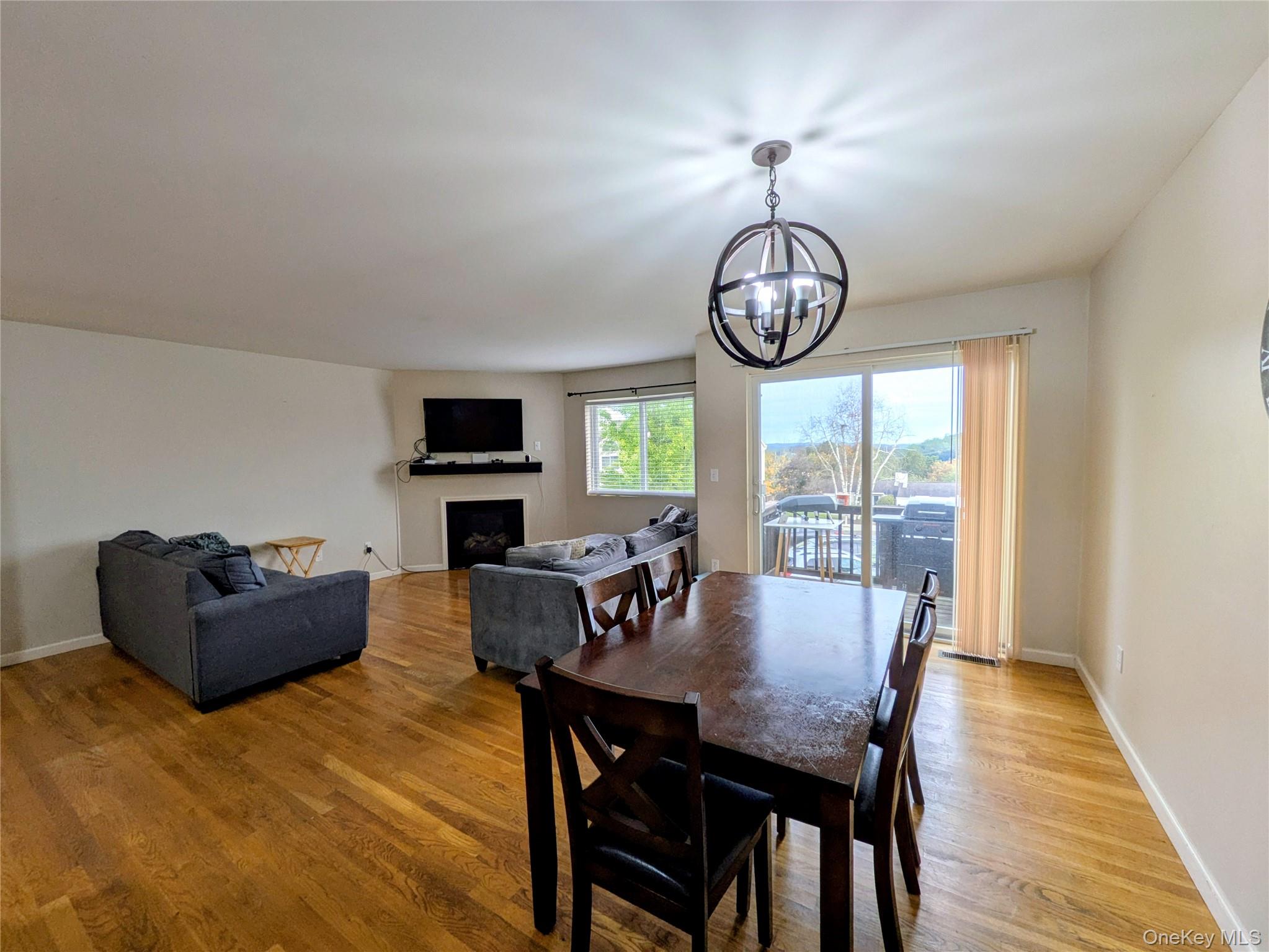1206 Eagles Ridge Road Brewster, NY 10509 - Photo 6 of 29 Dining area featuring a fireplace, light wood-style floors, and a chandelier