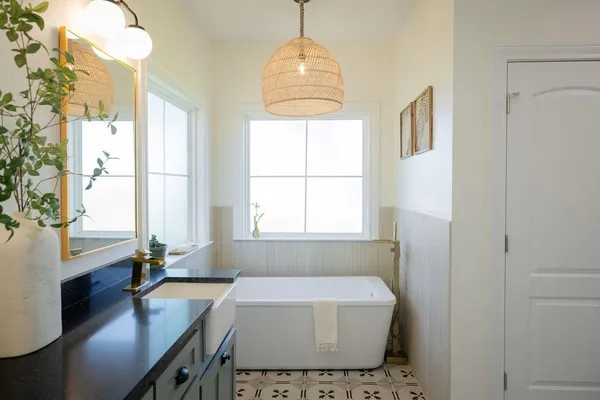 a bathroom with a granite countertop sink a mirror and a shower