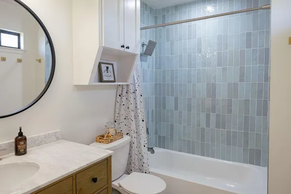 a bathroom with a granite countertop toilet sink and mirror