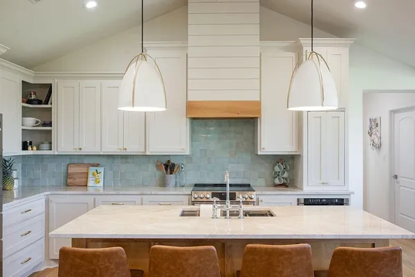 a kitchen with kitchen island granite countertop a sink a counter space and cabinets