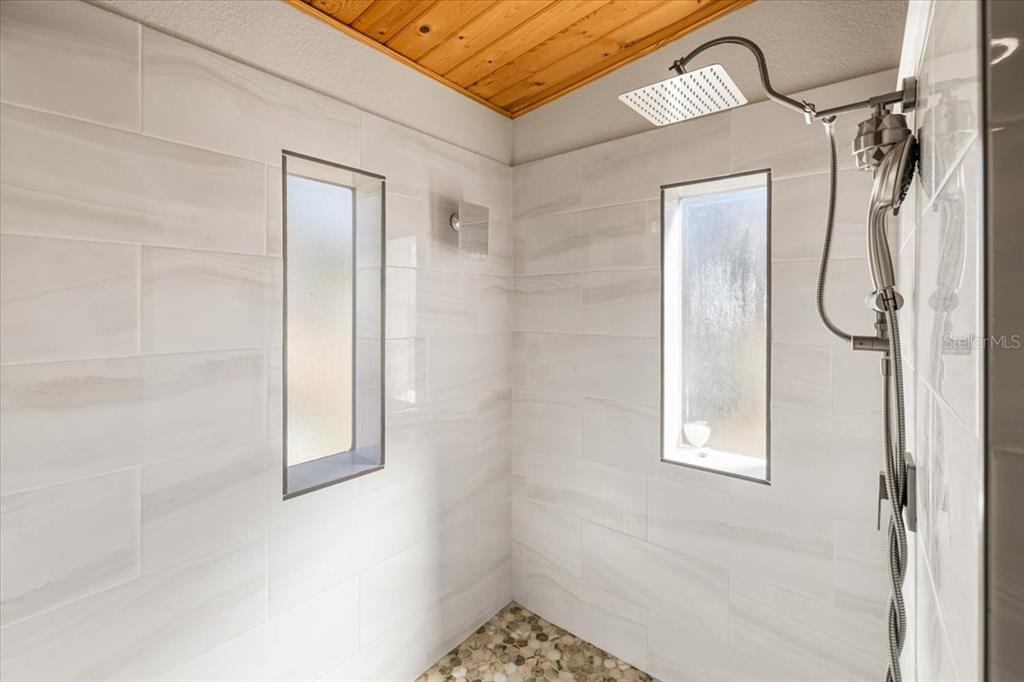 13205 Star Road Brooksville, FL 34613 - Photo 19 of 40 a bathroom with a glass shower door