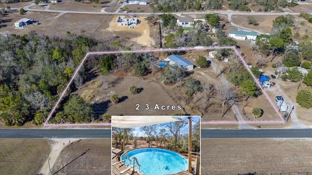 13205 Star Road Brooksville, FL 34613 - Photo 2 of 40 an aerial view of a house with a yard and lake view
