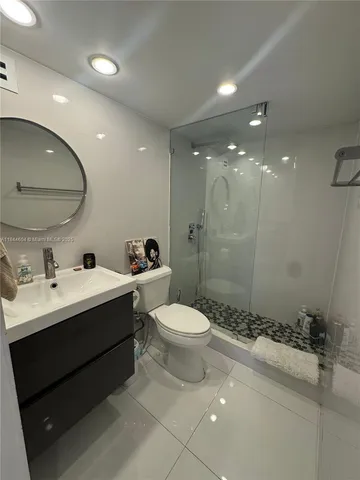 a bedroom with a bed and a black mirror