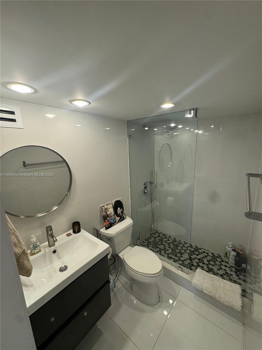 2150 Sans Souci Boulevard, Unit B1611 North Miami, FL 33181 - Photo 17 of 21 a bathroom with a toilet sink shower and mirror