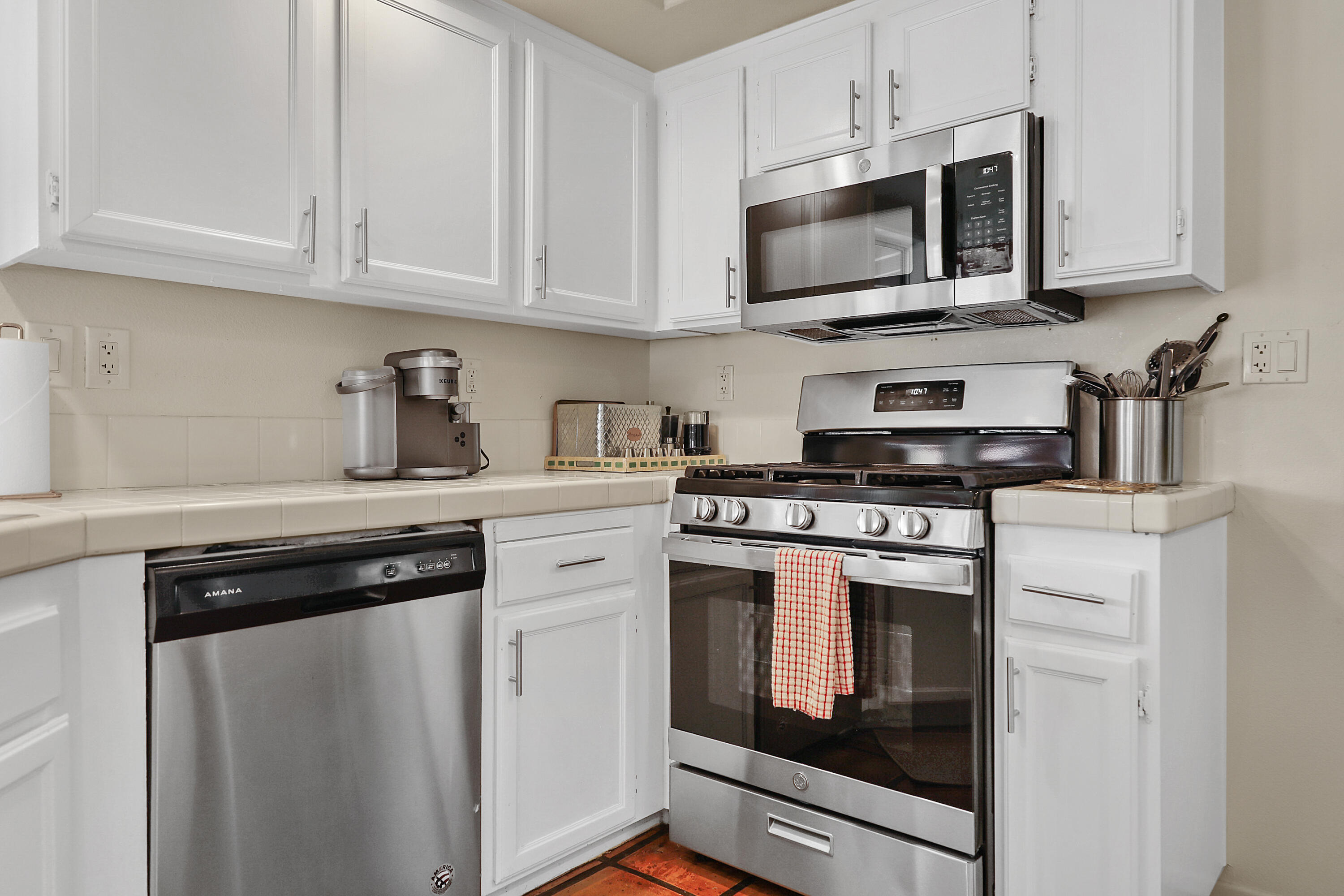 80380 Paseo Encanto Indio, CA 92201 - Photo 17 of 32 a kitchen with stainless steel appliances granite countertop a stove a microwave and a white cabinets