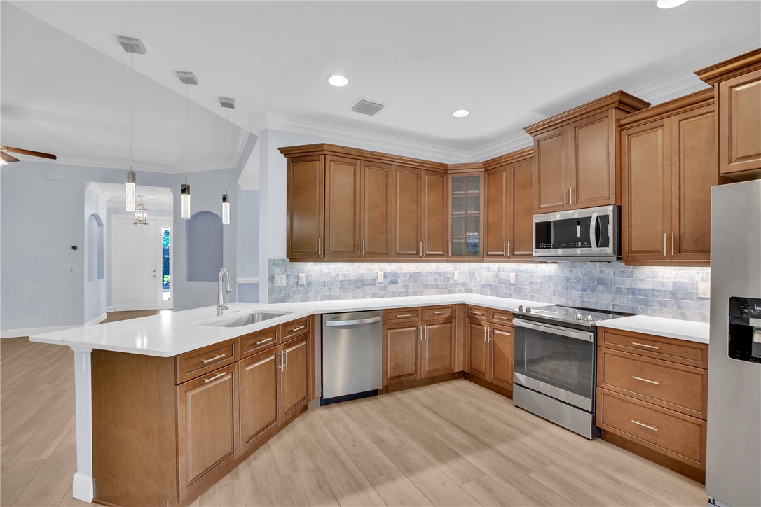 239 11th Square Southwest Vero Beach, FL 32962 - Photo 20 of 36 a kitchen with stainless steel appliances granite countertop a sink stove and refrigerator
