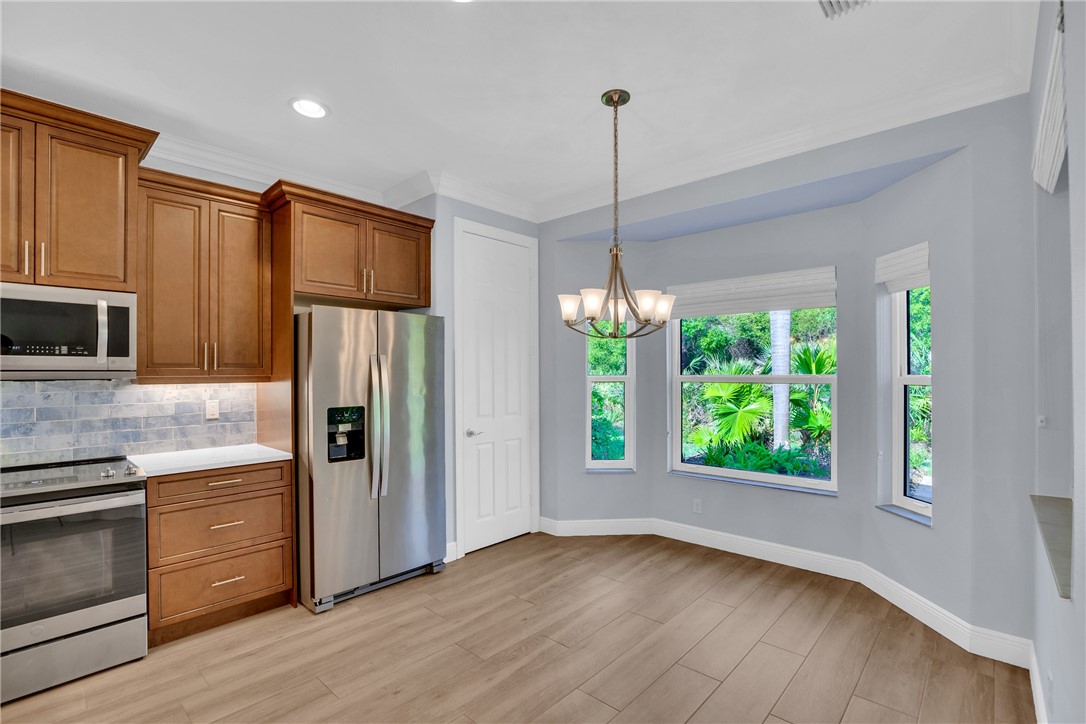 239 11th Square Southwest Vero Beach, FL 32962 - Photo 21 of 36 a kitchen with stainless steel appliances granite countertop a refrigerator a oven a sink and a wooden floors