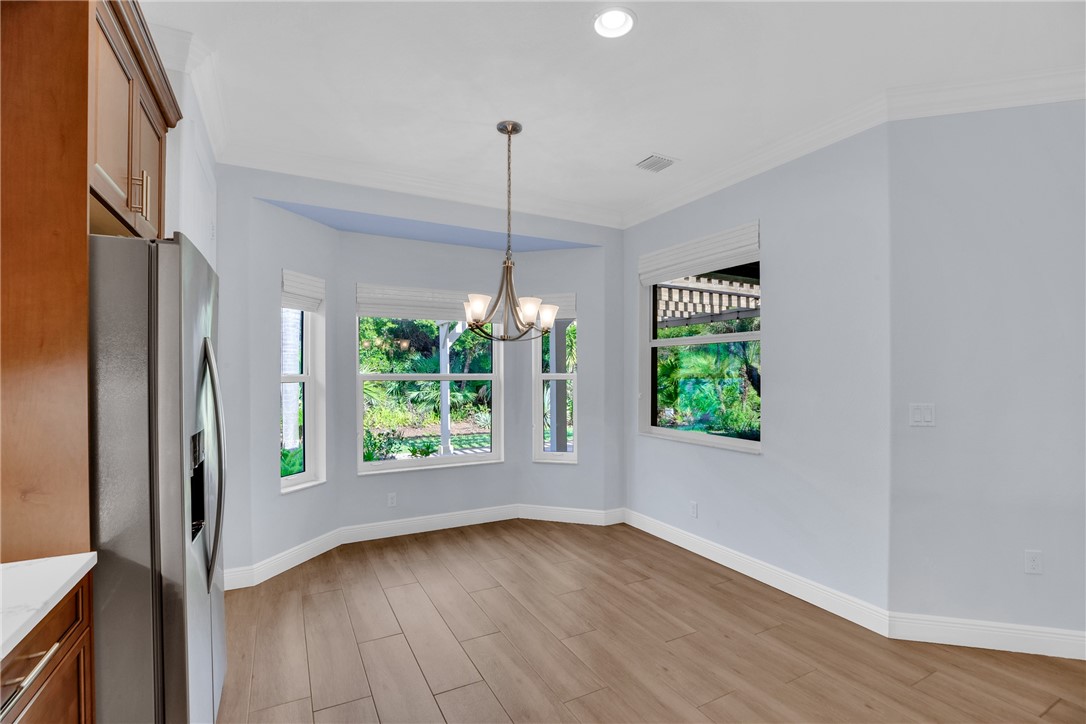 239 11th Square Southwest Vero Beach, FL 32962 - Photo 22 of 36 a view of an empty room with wooden floor fridge and a window