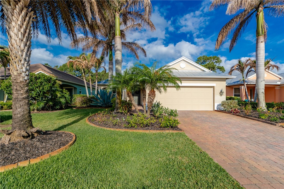 239 11th Square Southwest Vero Beach, FL 32962 - Photo 3 of 36 a front view of a house with a garden and a yard