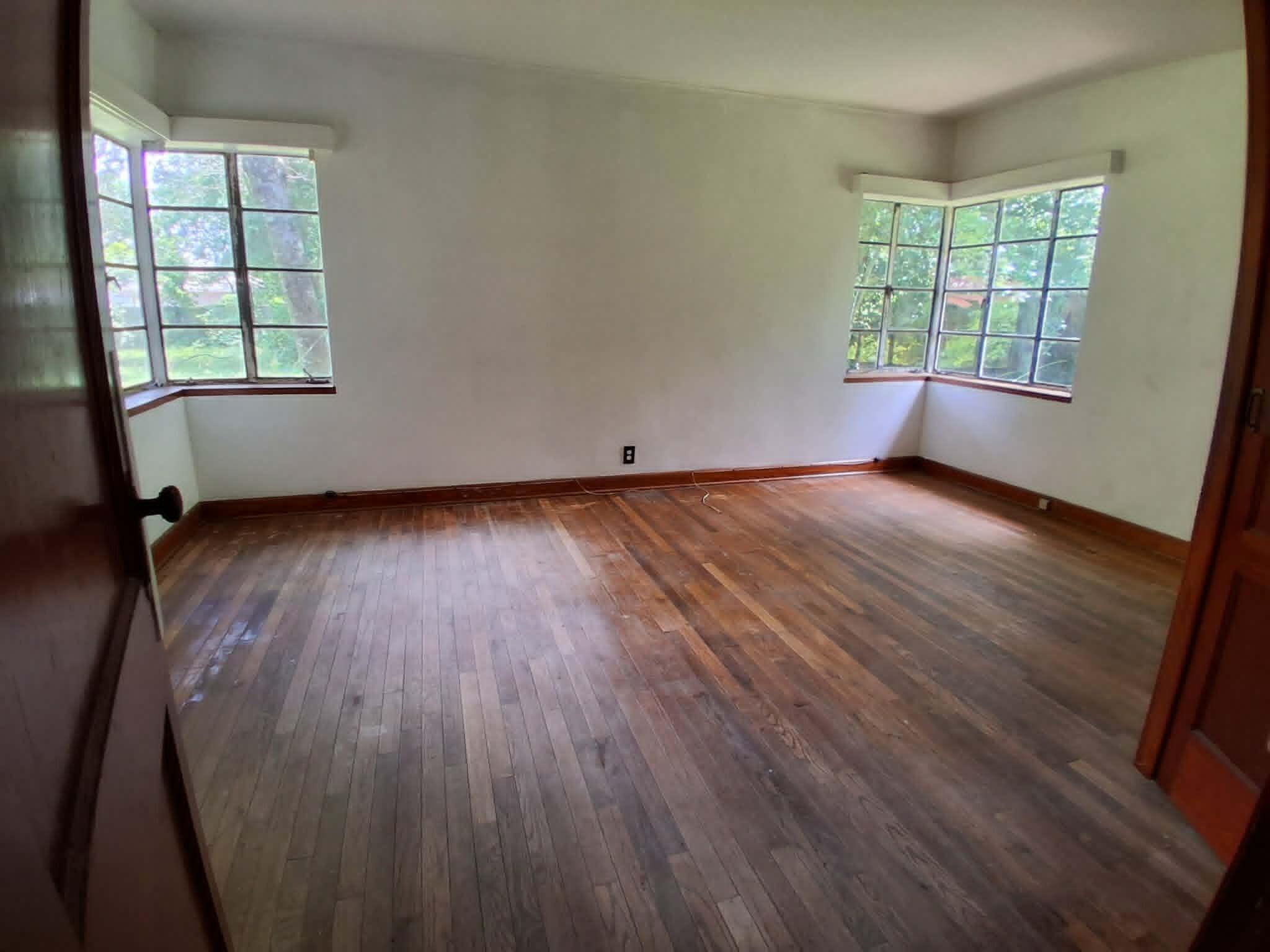 855 North Pearl Street Crestview, FL 32536 - Photo 18 of 31 an empty room with wooden floor and windows