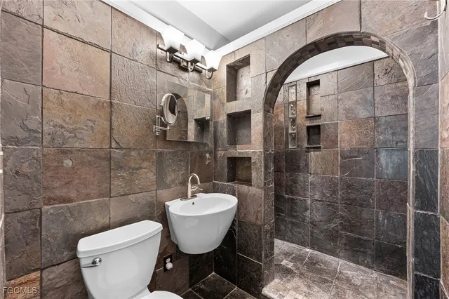 a bathroom with a toilet a sink and mirror