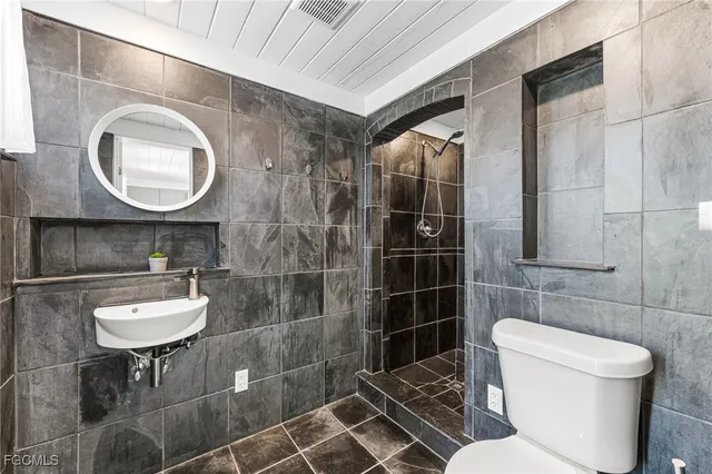 a bathroom with a toilet a sink and mirror