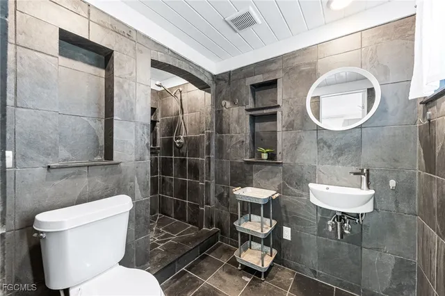 a bathroom with a toilet a sink and mirror