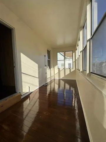 a view of a living room with hardwood floor and a large window