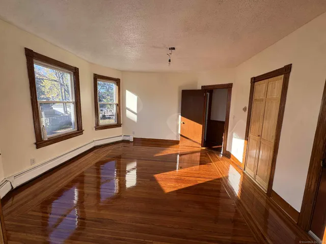 a view of a livingroom with wooden floor and staircase