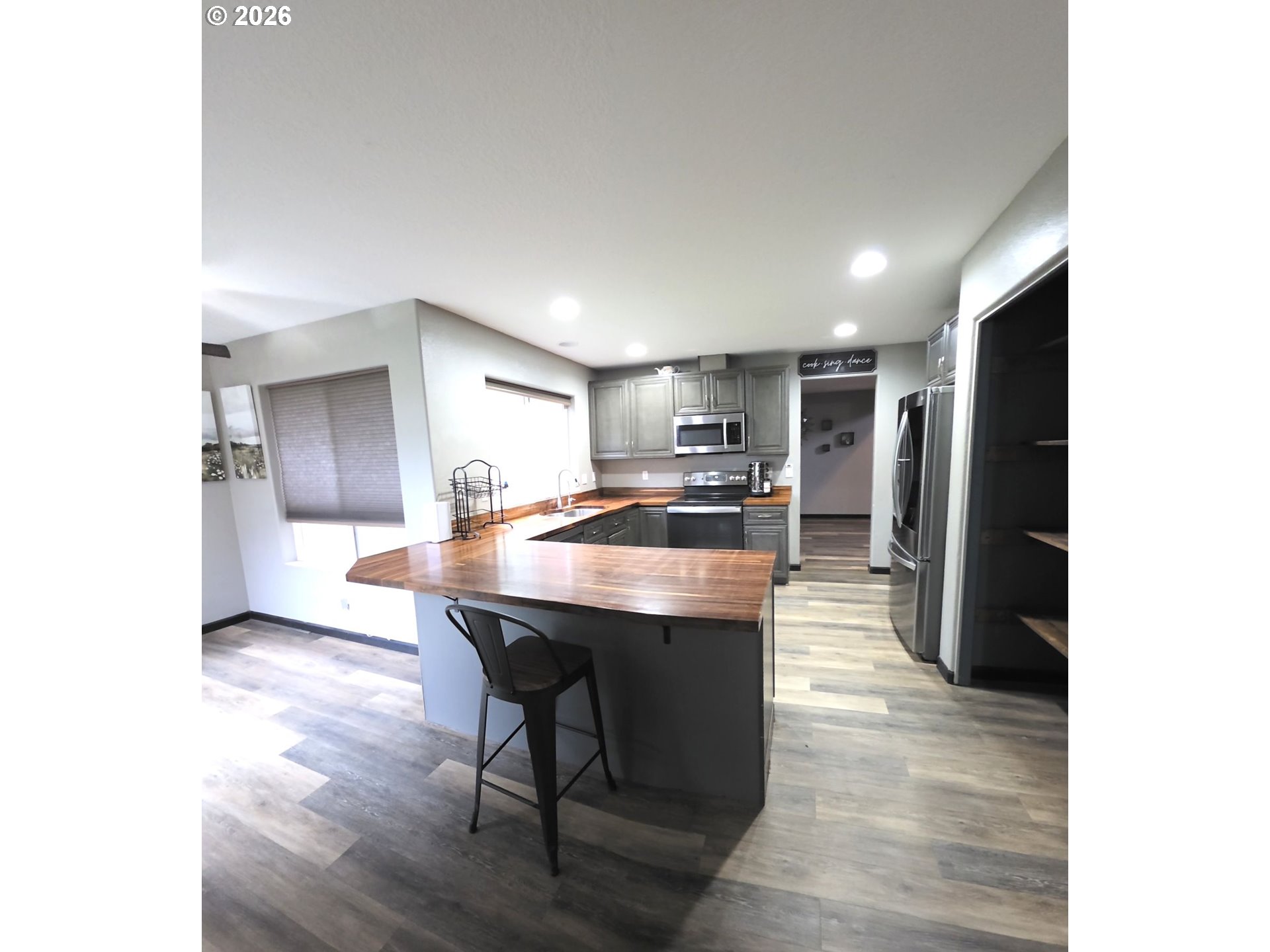 2703 Southwest 11th Street Battle Ground, WA 98604 - Photo 3 of 16 a kitchen with stainless steel appliances kitchen island granite countertop a table chairs and a refrigerator