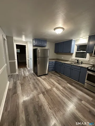 a kitchen with stainless steel appliances granite countertop a refrigerator and a sink