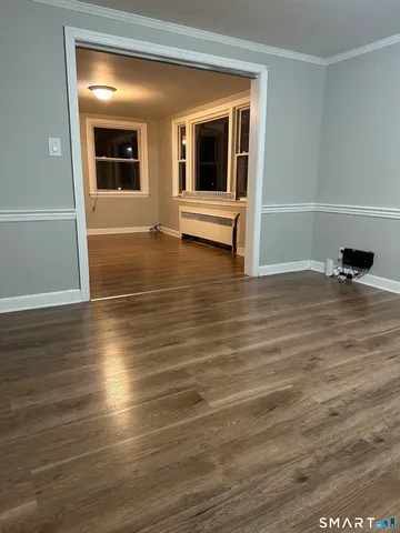 a view of a room with wooden floor and window