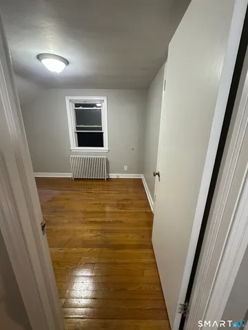 a view of empty room with wooden floor
