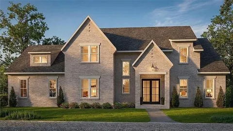 a front view of a house with a yard and plants