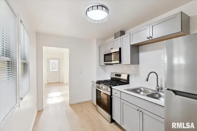 a kitchen with stainless steel appliances granite countertop a sink stove and microwave