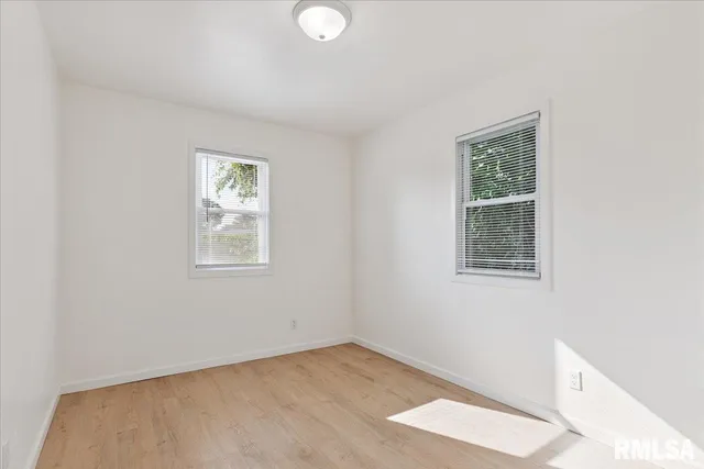 a view of an empty room with window and closet area