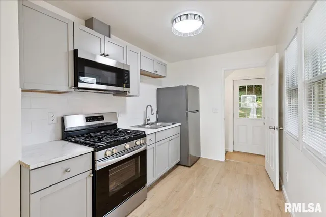 a kitchen with stainless steel appliances granite countertop a sink and a stove top oven