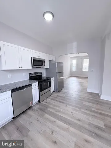 a large kitchen with cabinets and wooden floor