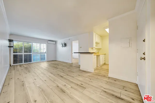 a view of empty room with wooden floor and cabinet