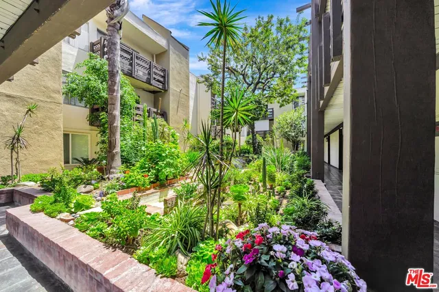 a backyard of a house with a garden and outdoor seating