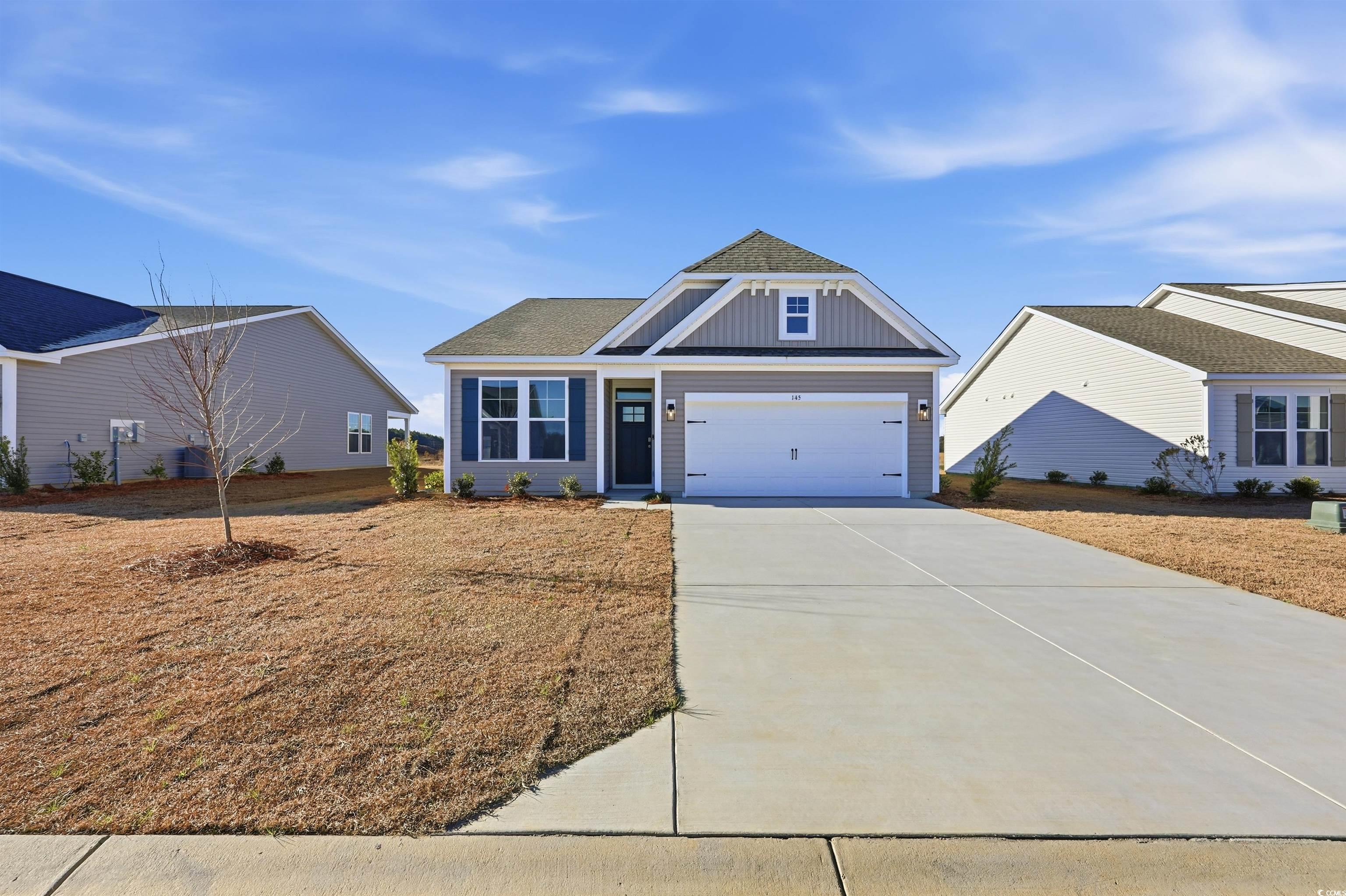 View of front of house with concrete driveway, board and batten siding, a garage, and roof with shingles