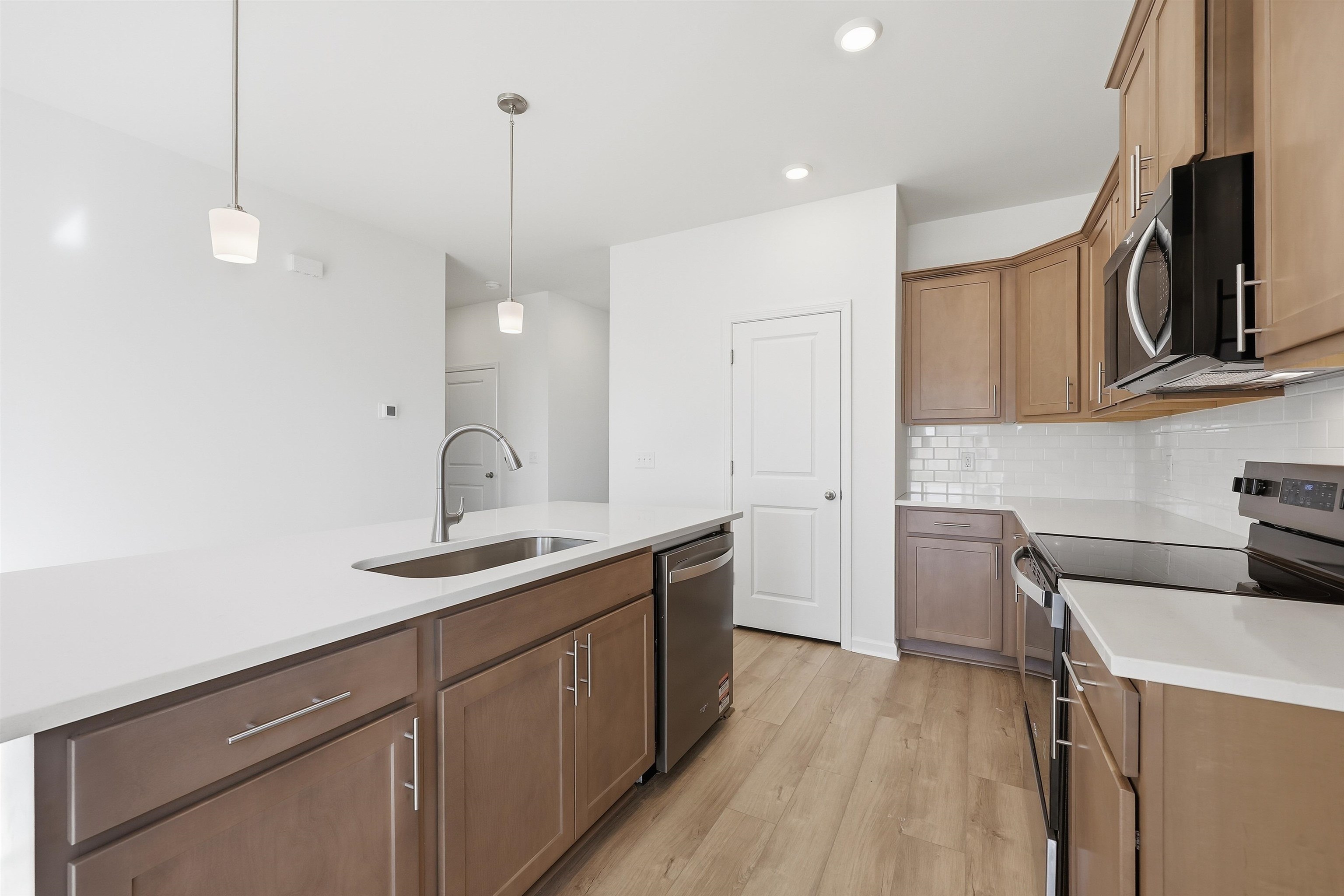 145 River Birch Drive Loris, SC 29569 - Photo 6 of 36 Kitchen with stainless steel appliances, pendant lighting, light wood-style flooring, light stone counters, and backsplash