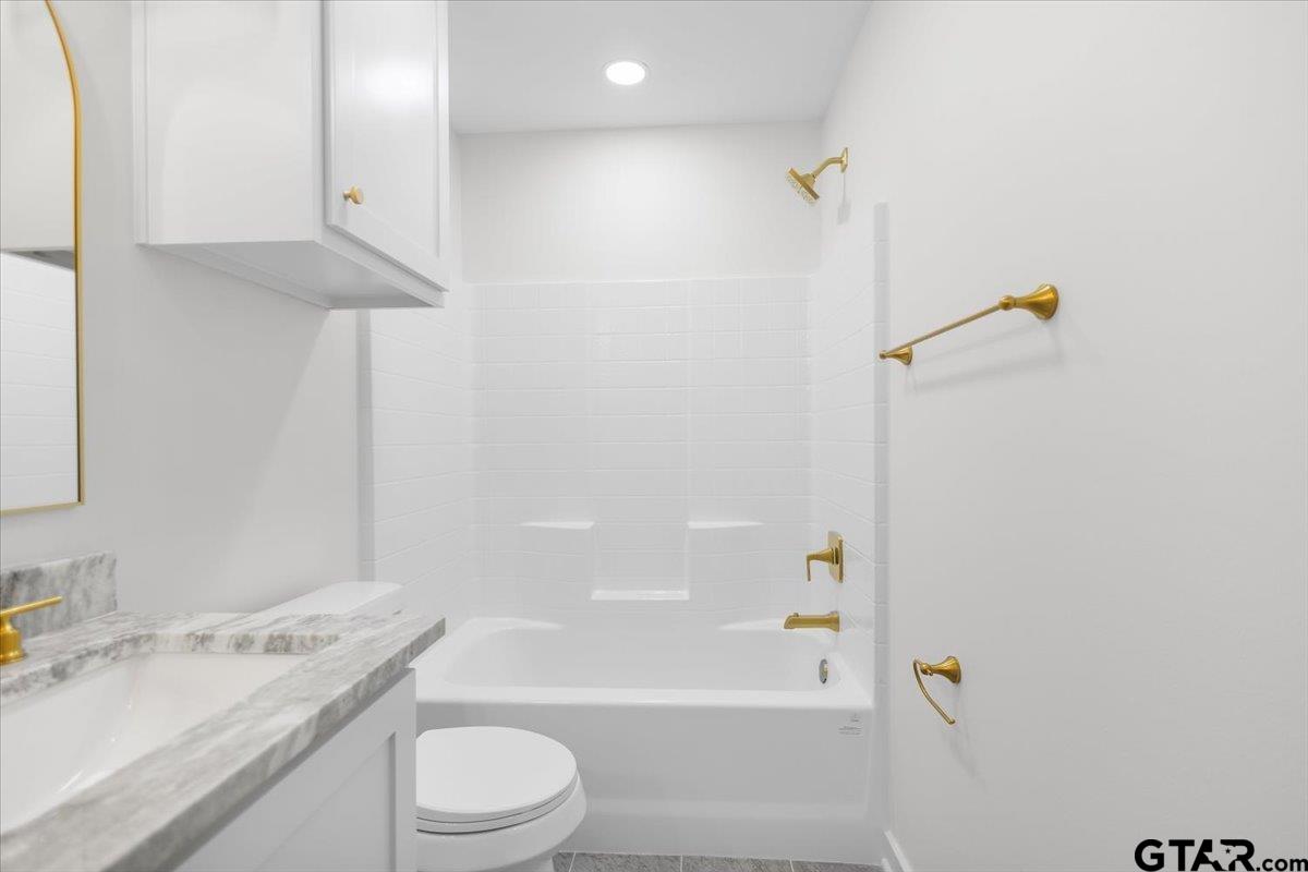 435 West Harmony Street Tyler, TX 75702 - Photo 16 of 22 a bathroom with a granite countertop sink a toilet and shower