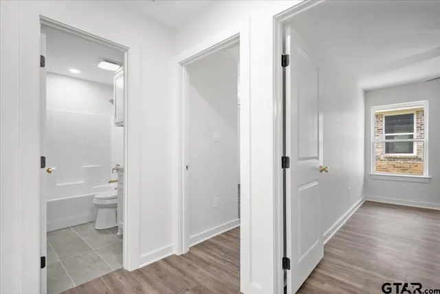 a view of a bathroom with toilet front door and wooden floor