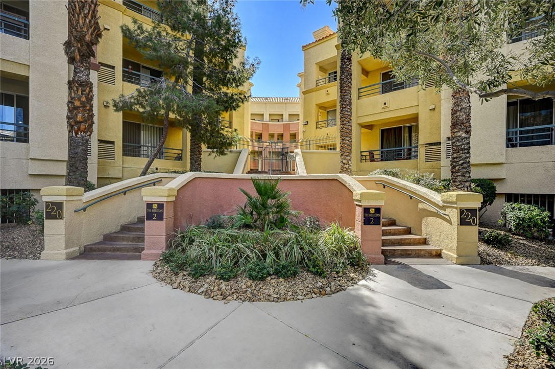 210 East Flamingo Road, Unit 208 Las Vegas, NV 89169 - Photo 33 of 42 Venture into this complex featuring multiple stories and a vibrant desert-inspired landscape with palms and greenery.
