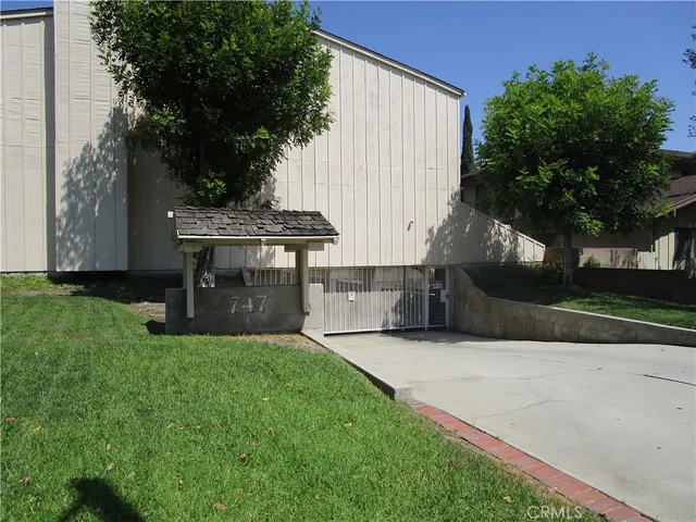a view of a house with a garden and sitting area