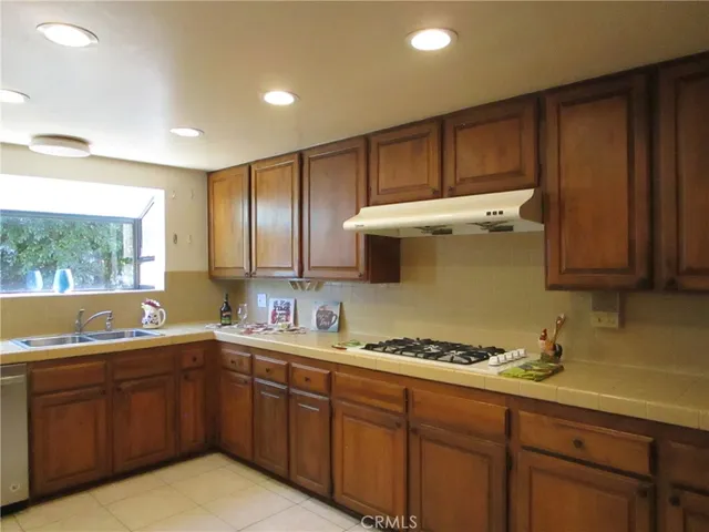 a kitchen with a sink a stove cabinets and wooden floor