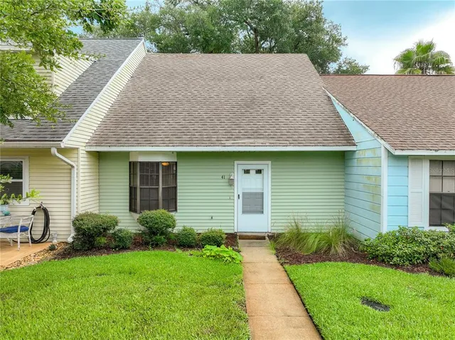 a aerial view of a house next to a yard