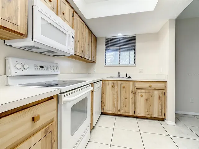 a kitchen with stainless steel appliances granite countertop white cabinets and window