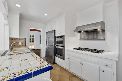 a kitchen with stainless steel appliances kitchen island granite countertop a stove and a refrigerator