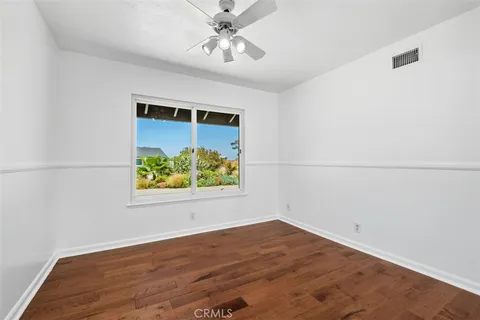 an empty room with a window and a ceiling fan