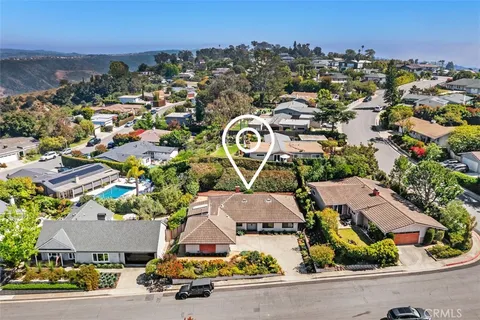 an aerial view of residential houses with outdoor space and parking
