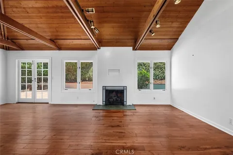 a view of empty room with wooden floor and fireplace