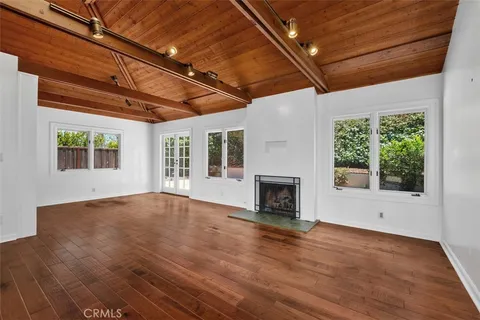 a view of empty room with wooden floor and fireplace