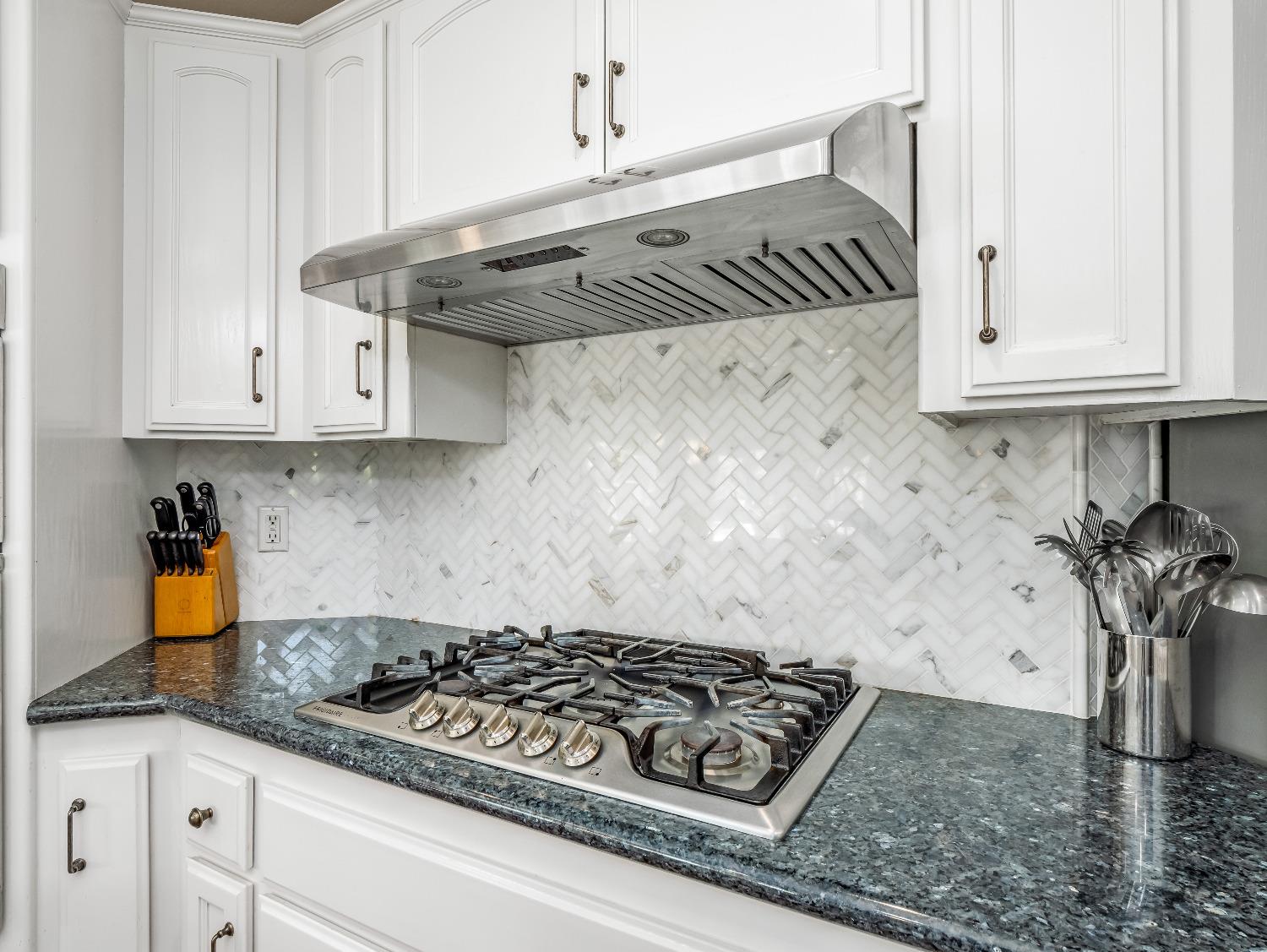 12 Breeze Way Madera, CA 93637 - Photo 14 of 48 a kitchen with granite countertop a stove sink and cabinets